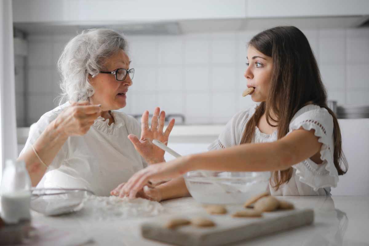 Elderly woman making cookies with daughter